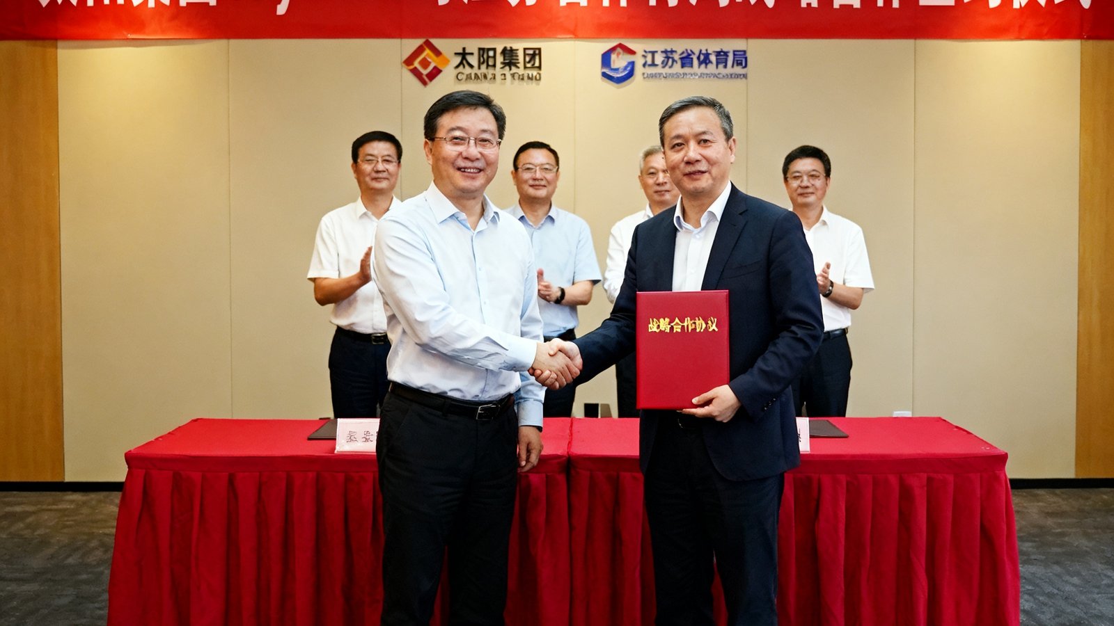 太阳集团tcy8722与江苏省体育局战略合作签约仪式现场照片，双方代表在签约台前握手并展示合作协议文件